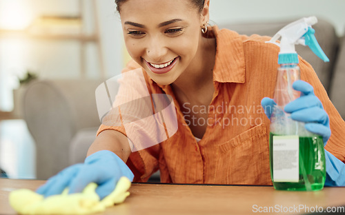 Image of Spray, woman and smile for cleaning table, furniture and housekeeping services at home. Female cleaner wipe surface with cloth, bottle of chemical product and disinfection of dust, bacteria and dirt