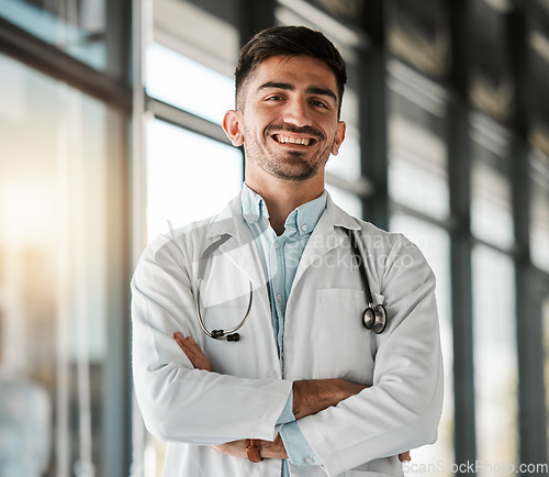 Image of Crossed arms, confidence and portrait of a male doctor with a stethoscope in a medical hospital. Happy, smile and headshot of a professional young man healthcare worker or surgeon in medicare clinic.