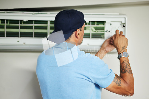 Image of Man, electrician and ac repair for air conditioner maintenance from the back. Mechanic, technician and engineering tools to fix power of aircon machine, hvac services and check electrical ventilation