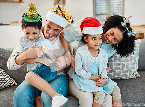 Image of Parents, kids and playing on sofa, christmas or tickling with comic laughing, game or excited in family home. Mother, father and happy young children with xmas celebration, relax and bonding or couch