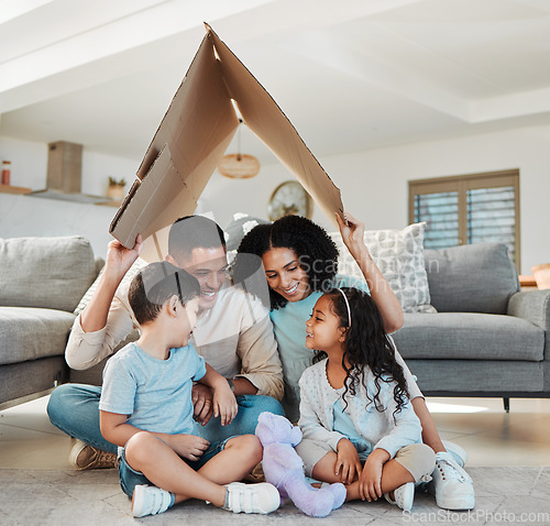 Image of Happy family, children and parents with home insurance, investment and safety or love on floor with mother and father. Kids and interracial people with cardboard roof for house cover and security