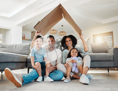 Image of Cardboard roof, portrait and a family in a home for security, safety and shelter as a family. Happy, house and a mother, father and children with refuge in a living room for insurance together