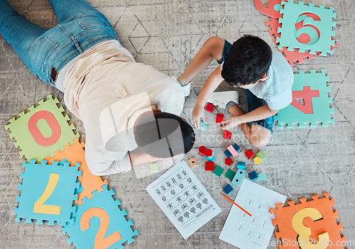 Image of Building blocks, above or father with kid on the floor for learning, education or child development at home. Family, play or dad enjoying bonding time in living room with boy or toys doing homework