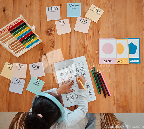 Image of Above, child and girl writing on table for homework or remote learning in home for development, growth and education. Kid, working and studying for school, math and writing on paper in living room