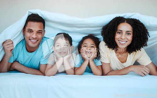 Image of Blanket, bed and portrait of parents with children for bonding, quality time and affection in morning. Love, family and happy mother, father and kids laying in bedroom for fun, playful and relaxing