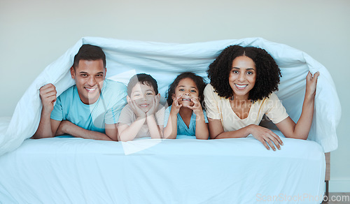 Image of Happy, blanket and portrait of family in bed for bonding, quality time and affection in morning. Parent, love and playful mother, father and kids in bedroom for having fun, sleeping and relaxing