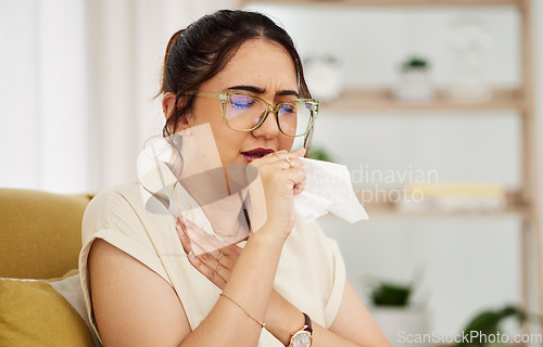 Image of Coughing, tissue and sick woman on a sofa with cold, flu or sore throat in her home. Allergies, influenza and female with viral infection, bacteria and covid risk in a living room with tuberculosis