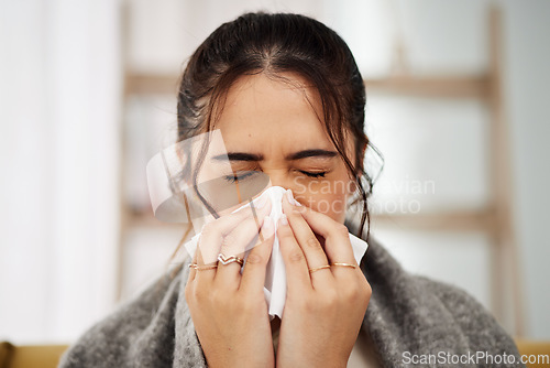 Image of Tissue, nose and sick woman sneezing in living room with allergy, cold or flu in her home. Hay fever, sinusitis and female with viral infection, risk or health crisis in lounge with congestion