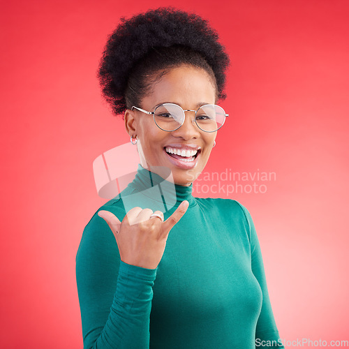 Image of Portrait, excited and black woman with call me hand in studio isolated on a red background with glasses. Face, happy and African person with shaka gesture, emoji sign and phone for communication