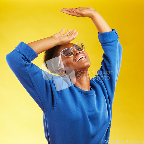 Image of Fashion, freedom and fun with a black woman on a yellow background in studio for trendy gen z style. Relax, smile and excited with a happy young girl indoor to dance with a carefree expression