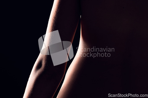 Image of Beauty, body and person on black background for creative lighting, shadow and silhouette. Aesthetic, skincare and closeup of waist in dark studio with macro of skin for art deco, wellness and glow