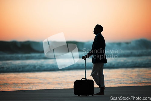 Image of Sunset, beach and man with suitcase for travel, vacation and break in nature with freedom and solo trip. Ocean, Silhouette, male at the sea at sunrise for holiday, experience and abroad relocation