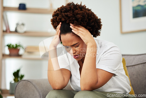 Image of Stress, headache and woman on a sofa in the living room of her modern apartment with a burnout. Sick, migraine and exhausted young African female person relaxing on weekend in the lounge of her home.