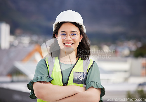 Image of Engineering, crossed arms and portrait of a female construction worker on a building rooftop. Confidence, industry and woman industrial manager for maintenance, renovation or inspection in the city.