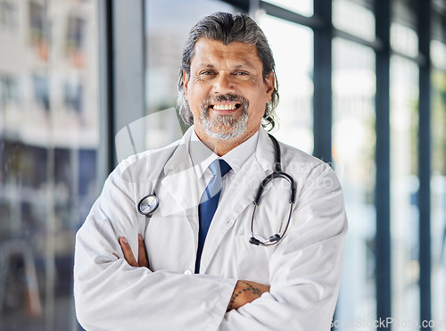 Image of Portrait, man and doctor with arms crossed, smile and surgeon with confidence, career and medicine. Face, mature person and medical professional in a hospital, healthcare expert and happy employee