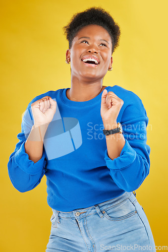 Image of Happy, dance and young woman in studio for celebration, achievement or goal with confidence. Happiness, smile and African female model moving to music, song or playlist isolated by yellow background.