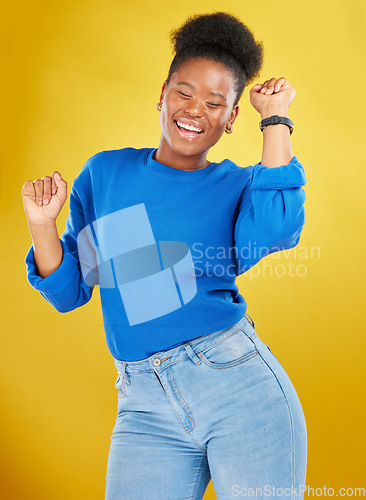 Image of Happy, dance and young woman in studio for celebration, achievement or goal with confidence. Happiness, smile and African female model moving to music, song or playlist isolated by yellow background.