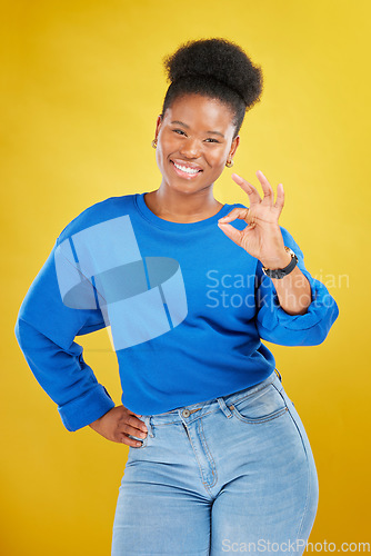 Image of Portrait, black woman and ok sign with a smile, review and feedback against a yellow studio background. Female person, gen z and model with perfect symbol, emoji and happiness with like, icon and yes