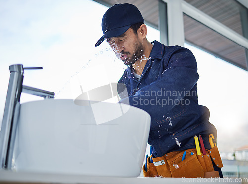 Image of Plumbing, fail and asian man in bathroom with water splash, crisis or basin leak or accident in a house. Faucet, emergency and male plumber with mistake, problem and pipe flood in home repairs