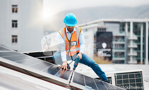 Image of Technician man, drill and solar panel on roof with installation, sustainability and construction in city. Engineer, tools and photovoltaic system with building, development or renewable energy in cbd