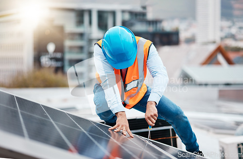 Image of Engineer man, screwdriver and solar panel on roof for maintenance, industry and construction in city. Technician, tools and photovoltaic system with helmet, development and renewable energy in cbd