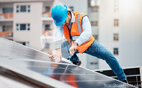 Image of Technician man, screwdriver and solar panel on roof for maintenance, industry and construction in city. Engineer, tools and photovoltaic system for building, development and renewable energy in cbd