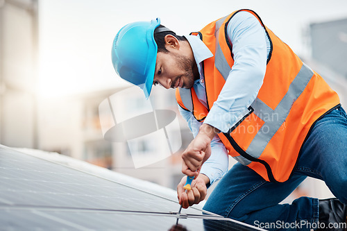 Image of Solar panels, tool and male engineer on a rooftop doing maintenance or repairs with screwdriver. Renovation, handyman and zoom of an industrial worker working on eco friendly construction on building