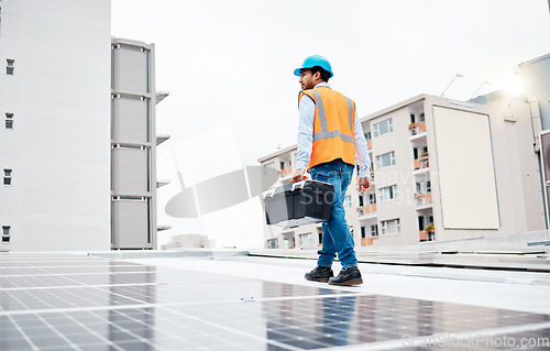 Image of Solar panel, tool box and electricity with man on roof top for renewable energy, project or power. Construction, engineering or technician with contractor in city for inspection and photovoltaic grid