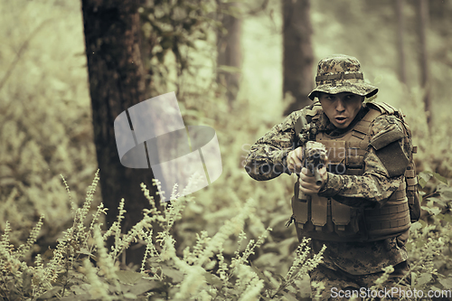 Image of A modern warfare soldier on war duty in dense and dangerous forest areas. Dangerous military rescue operations