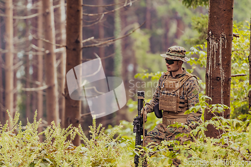 Image of A modern warfare soldier on war duty in dense and dangerous forest areas. Dangerous military rescue operations