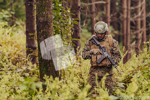 Image of A modern warfare soldier on war duty in dense and dangerous forest areas. Dangerous military rescue operations