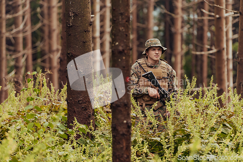 Image of A modern warfare soldier on war duty in dense and dangerous forest areas. Dangerous military rescue operations