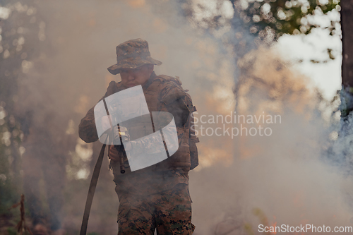 Image of A soldier fights in a warforest area surrounded by fire