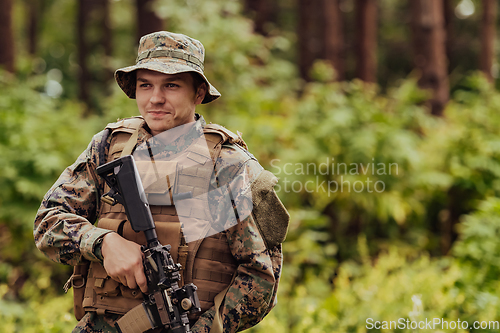 Image of A modern warfare soldier on war duty in dense and dangerous forest areas. Dangerous military rescue operations