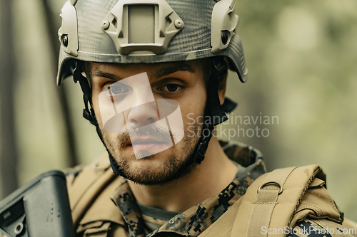 Image of Soldier portrait with protective army tactical gear and weapon having a break and relaxing