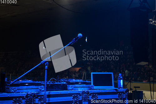 Image of microphone in concert hall with blue lights