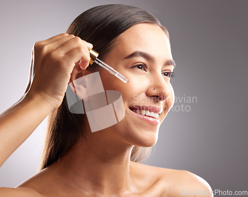 Image of Beauty, face and happy woman with serum dropper for skincare hydration, facial cosmetics glow or anti aging wellness. Collagen oil treatment, dermatology and studio person on gradient grey background