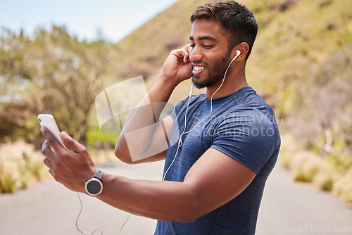 Image of Fitness, happy man or runner with music on mobile app online in training, workout or exercise on road. Headphones, radio audio or healthy athlete listening or streaming podcast to start running
