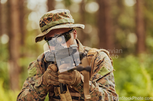 Image of A modern warfare soldier on war duty in dense and dangerous forest areas. Dangerous military rescue operations