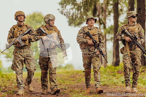 Image of Soldier fighters standing together with guns. Group portrait of US army elite members, private military company servicemen, anti terrorist squad