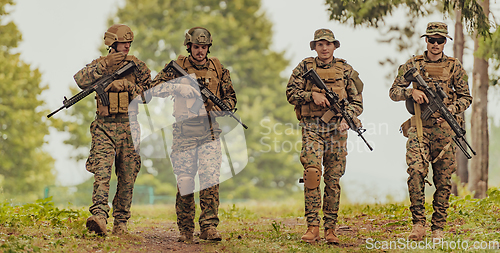 Image of Soldier fighters standing together with guns. Group portrait of US army elite members, private military company servicemen, anti terrorist squad