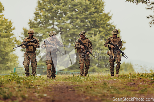 Image of Soldier fighters standing together with guns. Group portrait of US army elite members, private military company servicemen, anti terrorist squad