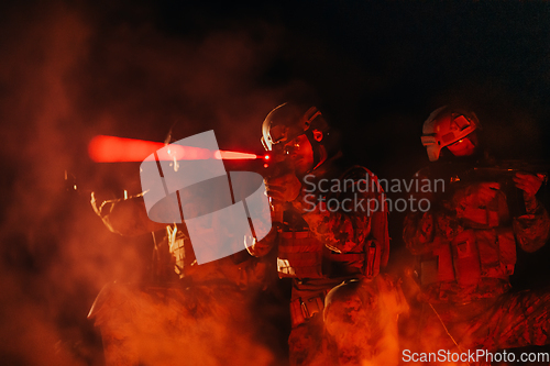 Image of Soldiers squad in action on night mission using laser sight beam lights military team concept