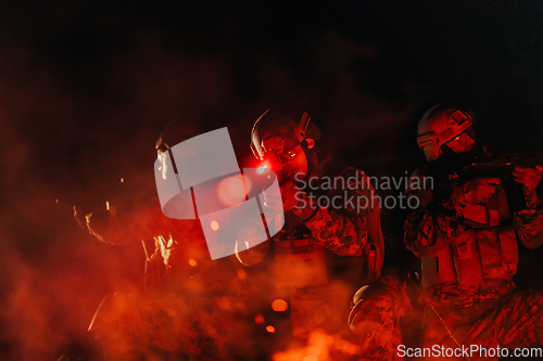 Image of Soldiers squad in action on night mission using laser sight beam lights military team concept