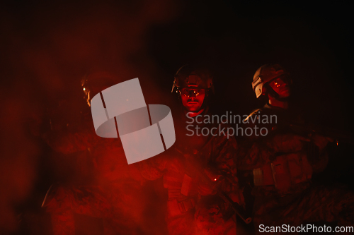 Image of Soldiers squad in action on night mission using laser sight beam lights military team concept