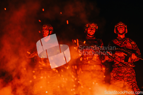 Image of Soldiers squad in action on night mission using laser sight beam lights military team concept