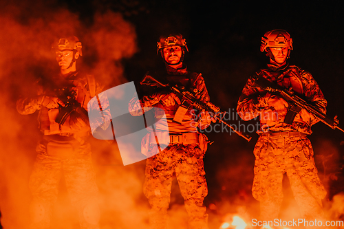 Image of Soldiers squad in action on night mission using laser sight beam lights military team concept