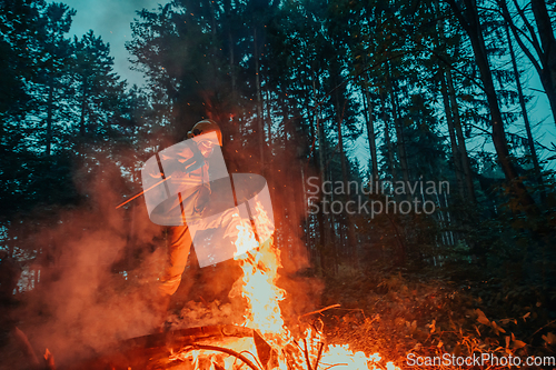 Image of firefighter hero in action danger jumping over fire flame to rescue and save