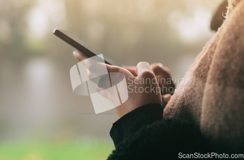 Image of Hands, phone and social media with a person on a blurred background outdoor on an overcast day. Mobile, contact and communication with an adult typing a text message in the rain during winter