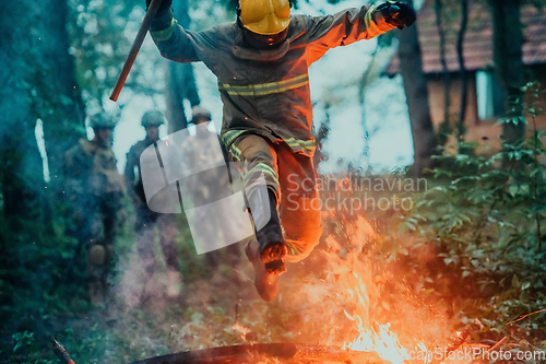 Image of firefighter hero in action danger jumping over fire flame to rescue and save